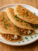 Panqueca Integral de Soja e Ricota dobrada em prato branco com salsinha picada por cima