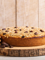 Biscoitos vitaminados de aveia com chocolate e uvas passa dourados em bandeja de madeira