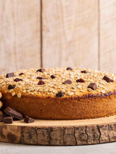 Biscoitos vitaminados de aveia com chocolate e uvas passa dourados em bandeja de madeira