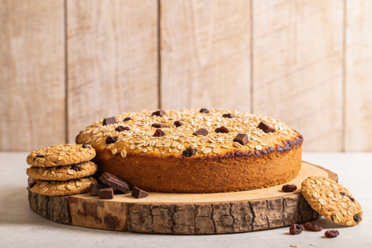 Biscoitos vitaminados de aveia com chocolate e uvas passa dourados em bandeja de madeira