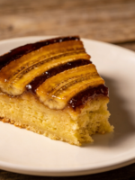 Fatia de bolo de banana de liquidificador fofinho com miolo aerado e cor amarelo-dourada em prato branco
