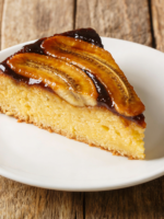 fatia de bolo de banana na air fryer fofinho com miolo aerado em prato branco
