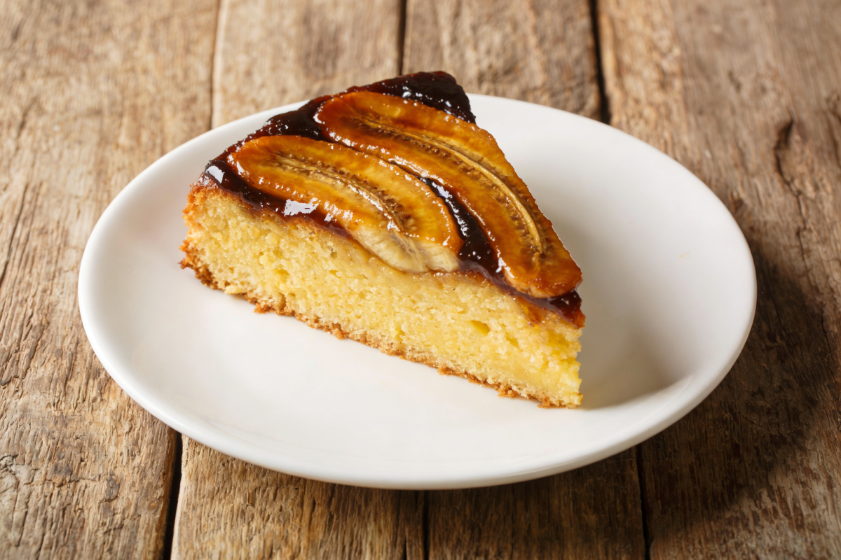 fatia de bolo de banana na air fryer fofinho com miolo aerado em prato branco
