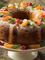 bolo de natal tradicional com frutas cristalizadas e açúcar de confeiteiro, servido em prato branco