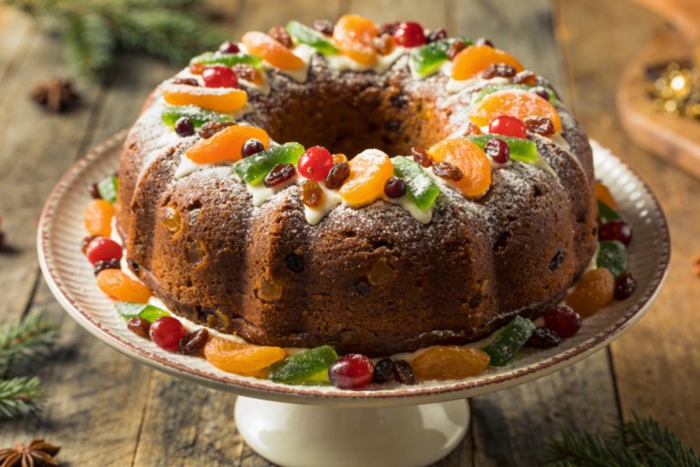 bolo de natal tradicional com frutas cristalizadas e açúcar de confeiteiro, servido em prato branco
