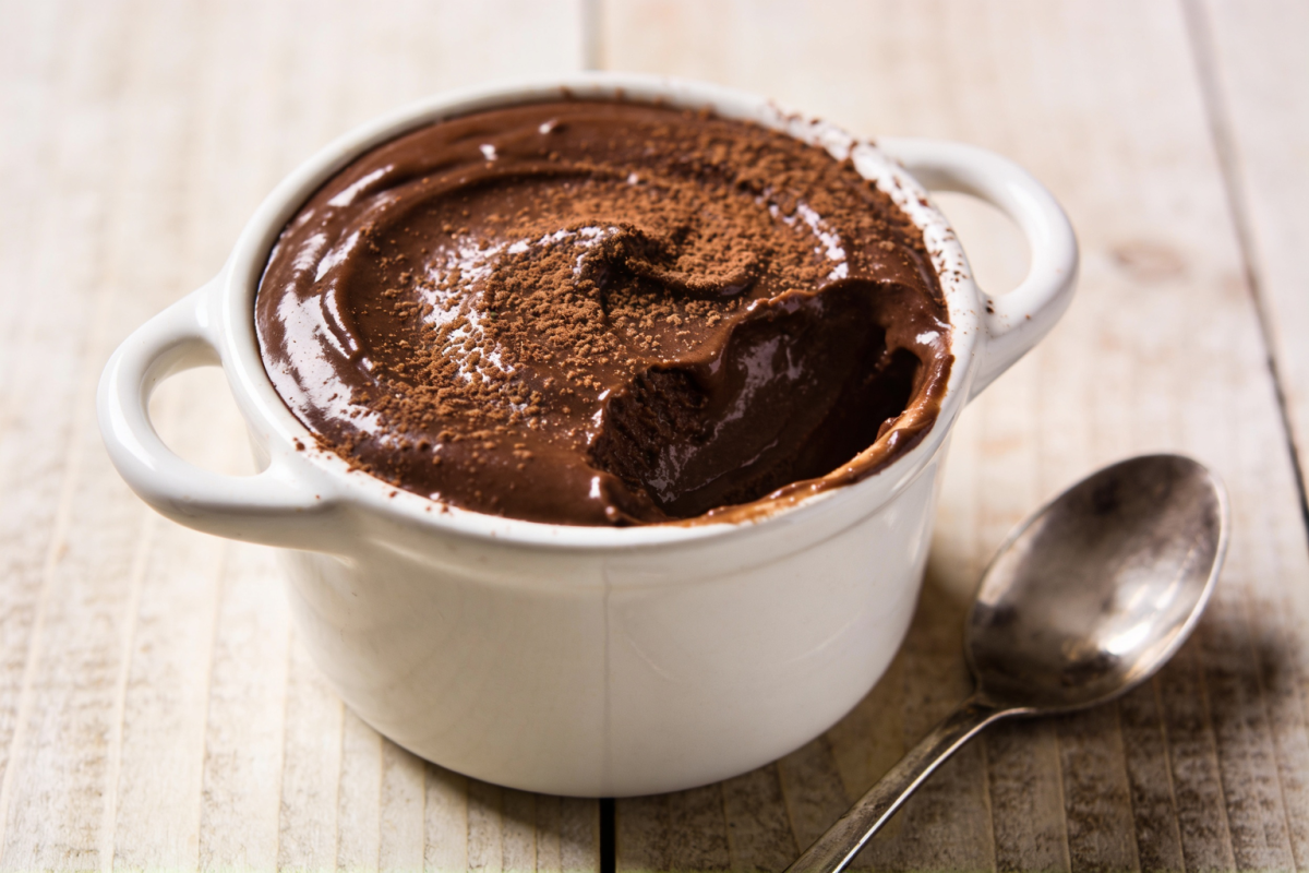 creme tipo chandele de chocolate cremoso servido em potinho branco com chocolate em pó polvilhado por cima