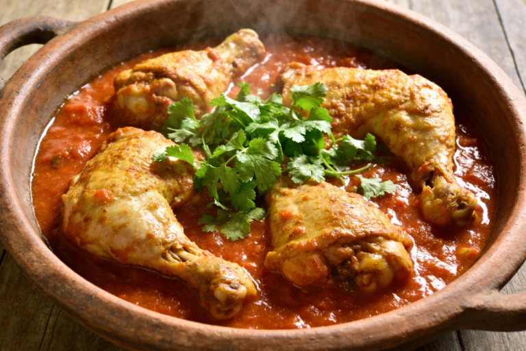frango de panela de pressão suculento com molho de tomate e cheiro-verde em panela de barro