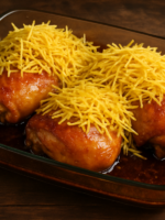 Frango malzbier assado com pele dourada e molho escuro em travessa de vidro, finalizado com batata palha crocante