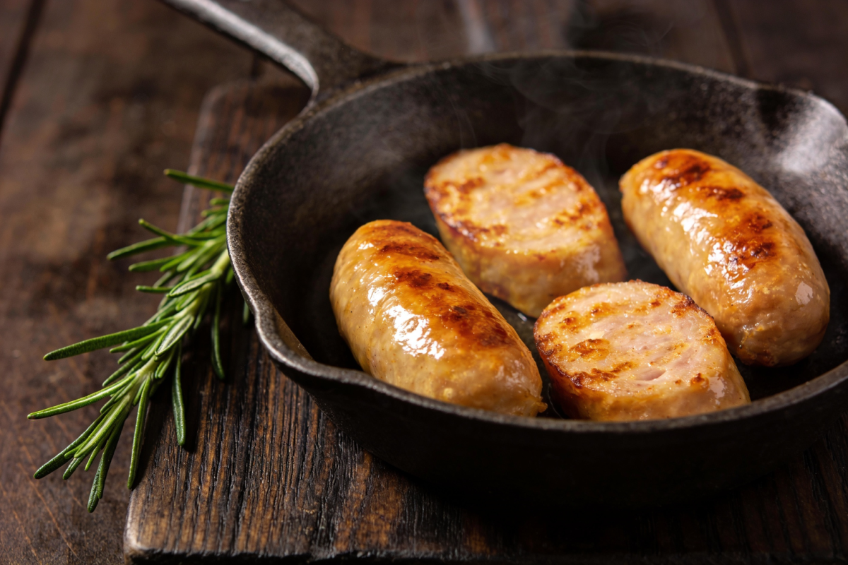 linguiça assada na frigideira com casca dourada e crocante servida em frigideira de ferro