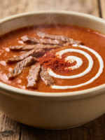 Sopa Eslava cremosa servida em tigela de cerâmica com tiras de carne e toque de páprica