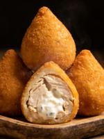 coxinha de frango cremosa dourada e crocante cortada ao meio mostrando recheio cremoso com requeijão