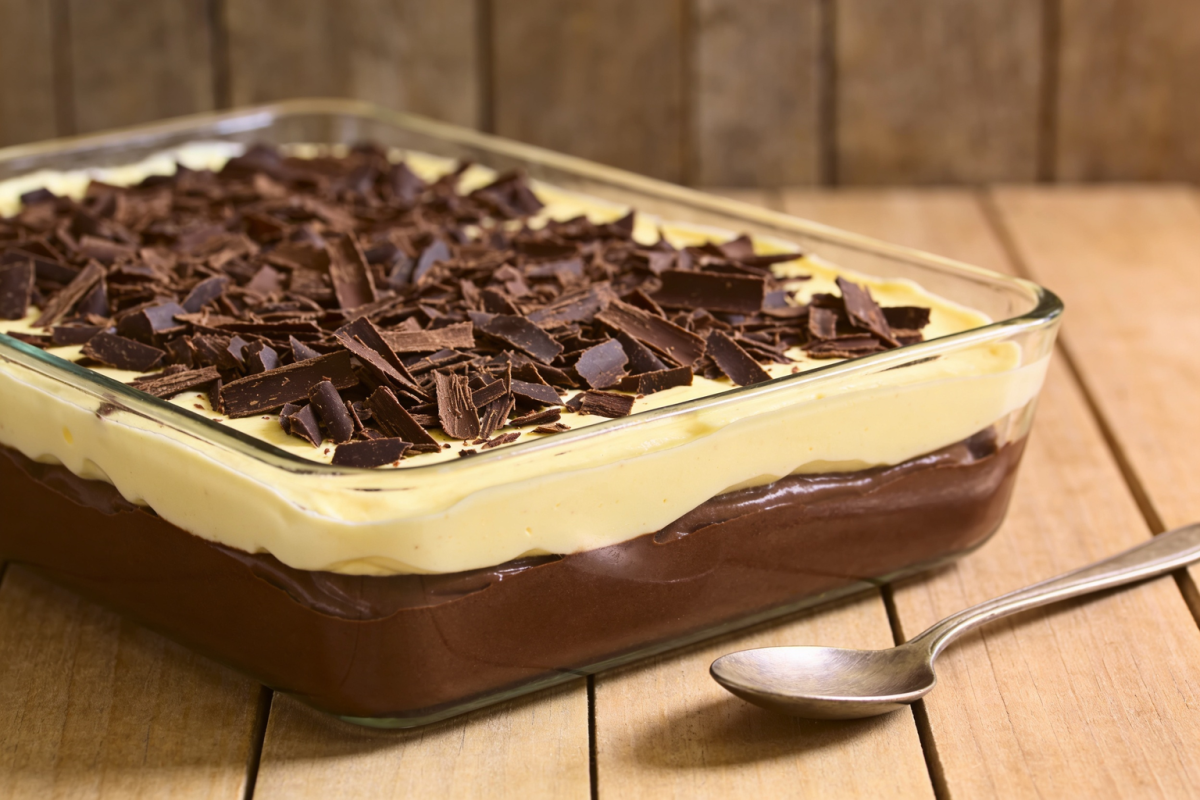 flan de chocolate ao creme de baunilha em camadas servido em refratária de vidro com raspas de chocolate por cima